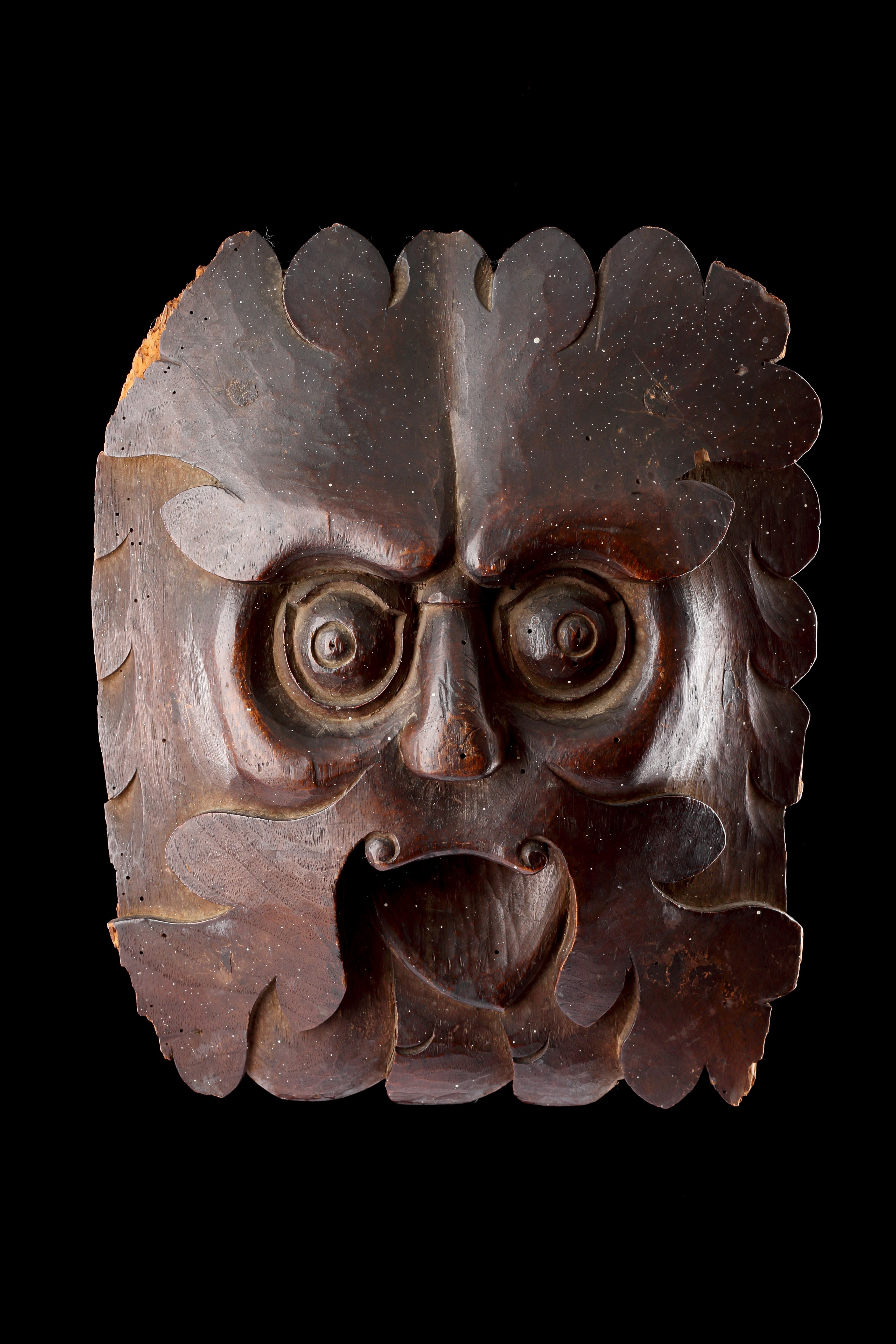 A Powerful Carved ‘Green Man’ with Piercing Eyes and Protruding Tongue